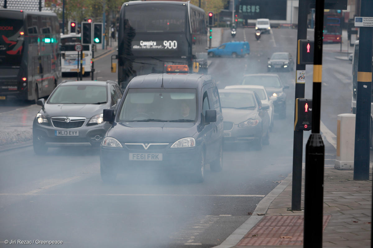Various shots of traffic in Birmingham city center, including details of car exhaust pipes in stationary traffic around the city.