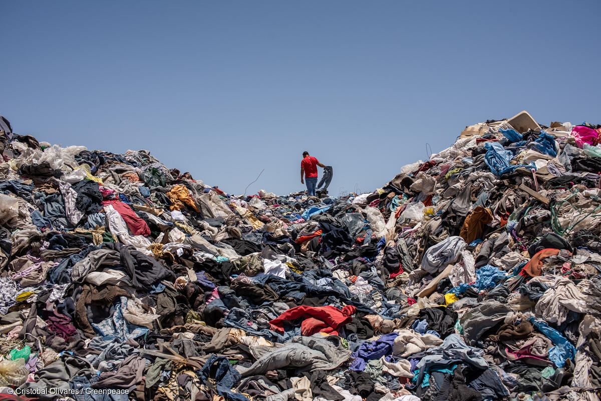 Freddy, a man who lives in a nearby squat looks for used clothes discarded in the Atacama desert, in Alto Hospicio, Iquique. Chile.