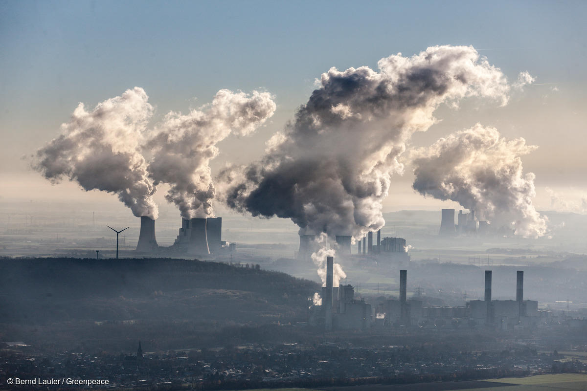 Aerial photo of coal fired power stations Neurath near Grevenbroich and Niederaussem near Bergheim in the Rhenish lignite mining area. Steam coming out of cooling towers. Windturbines near the plant.
