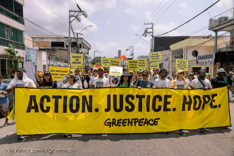 COP30で行われたグローバルクライメートマーチ。グリーンピースも先住民族グループや世界各国から集まった市民団体、数千人の人々とともに行進に参加。「行動。正義。希望」と書かれた横断幕。ブラジル、ベレン。2025年11月15日