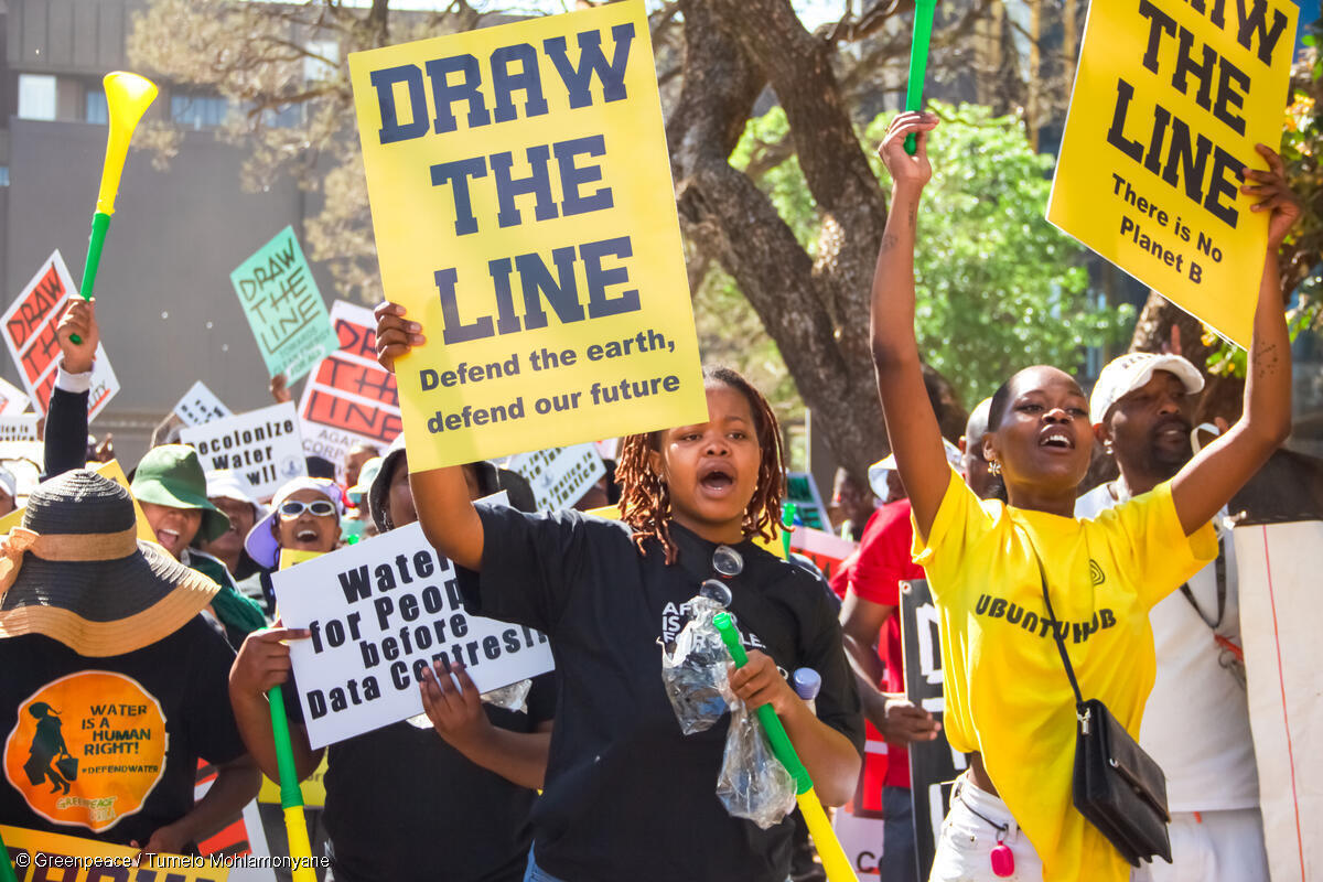 南アフリカで行われた気候正義を求めるデモ。「一線を引け。地球を守り、私たちの未来を守ろう」と書かれたパネルを掲げる参加者