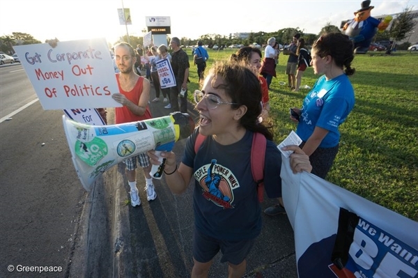 Activists hold signs outside the Democratic debate between presidential candidates Sec. Hillary Clinton and Sen. Bernie Sanders in Miami, Florida. 9 Mar, 2016 /  © Greenpeace