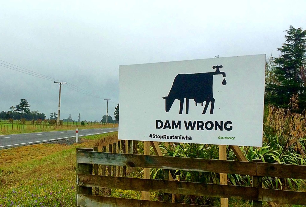 A Greenpeace ign reading 'Dam wrong' and 'stop Ruataniwha' with an image of a cow with a tap coming out of its rear end.