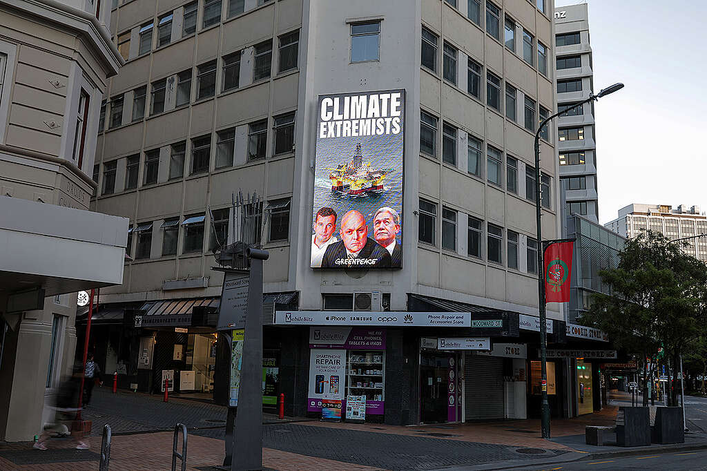 Christopher Luxon, David Seymour and Winston Peters are labelled as climate extremists on a billboard in Wellington with an offshore oil rig. © Greenpeace / Dave Lintott Christopher Luxon, David Seymour and Winston Peters are labelled as climate extremists on a billboard in Wellington with an offshore oil rig. © Greenpeace / Dave Lintott