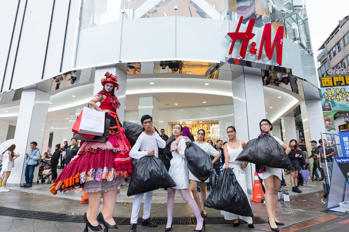 Trash Queen "Buy Nothing Day" Street Performance in Taipei. © JD Huang / Greenpeace Street performance against fast fashion outside an H&M store with a person on stilts and people carrying black rubbish bags
