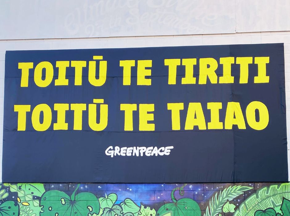 A billboard reads Toitū Te Tiriti, Toitū Te Taiao - Greenpeace