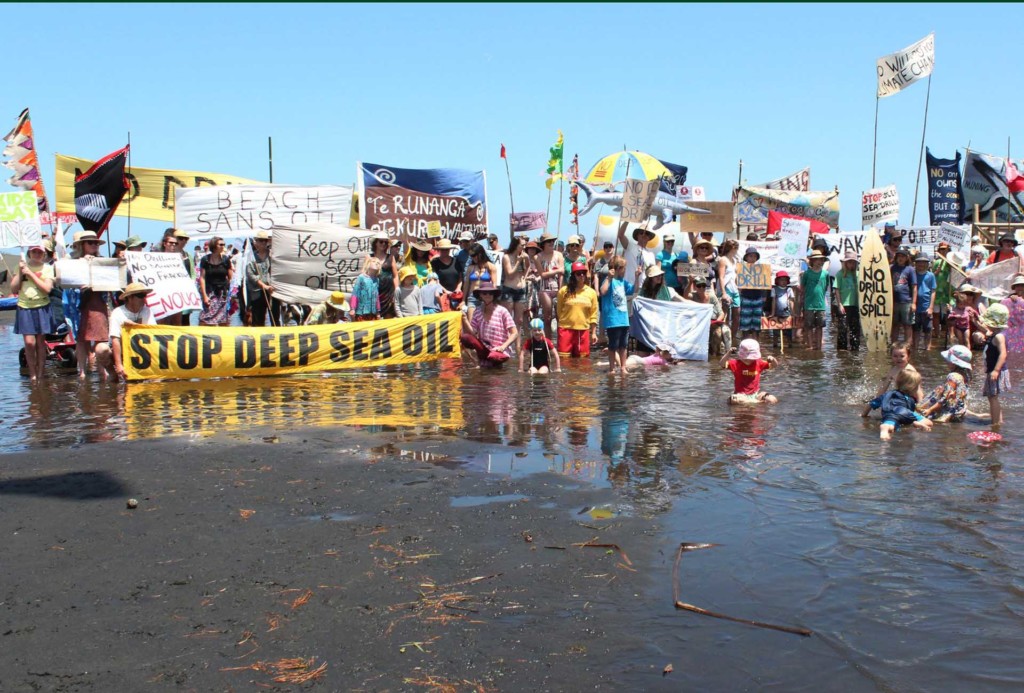People show their opposition to deep sea oil drilling in New Zealand waters at the 'banners on the beach' event at Bethells beach. Similar events are on at about 45 North Island west coast beaches and others are happening in solidarity on the east coast and in the South Island. They have been organised in support of the Oil Free Seas Flotilla which is protesting where oil giant Anadarko intends to start drilling. © Greenpeace / Lisa Marshall