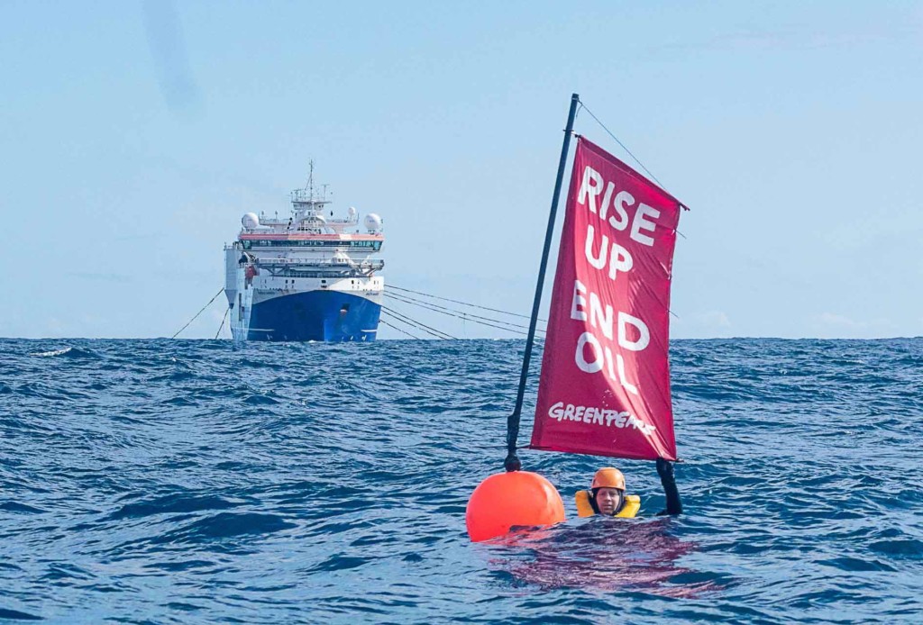 Greenpeace Executive Director Russel Norman swimming with buoy and banner that reads "Rise Up / End Oil" in front of seismic testing vessel Amazon Warrior. Greenpeace Executive Director Russel Norman swimming with buoy and banner that reads "Rise Up / End Oil" in front of seismic testing vessel Amazon Warrior.