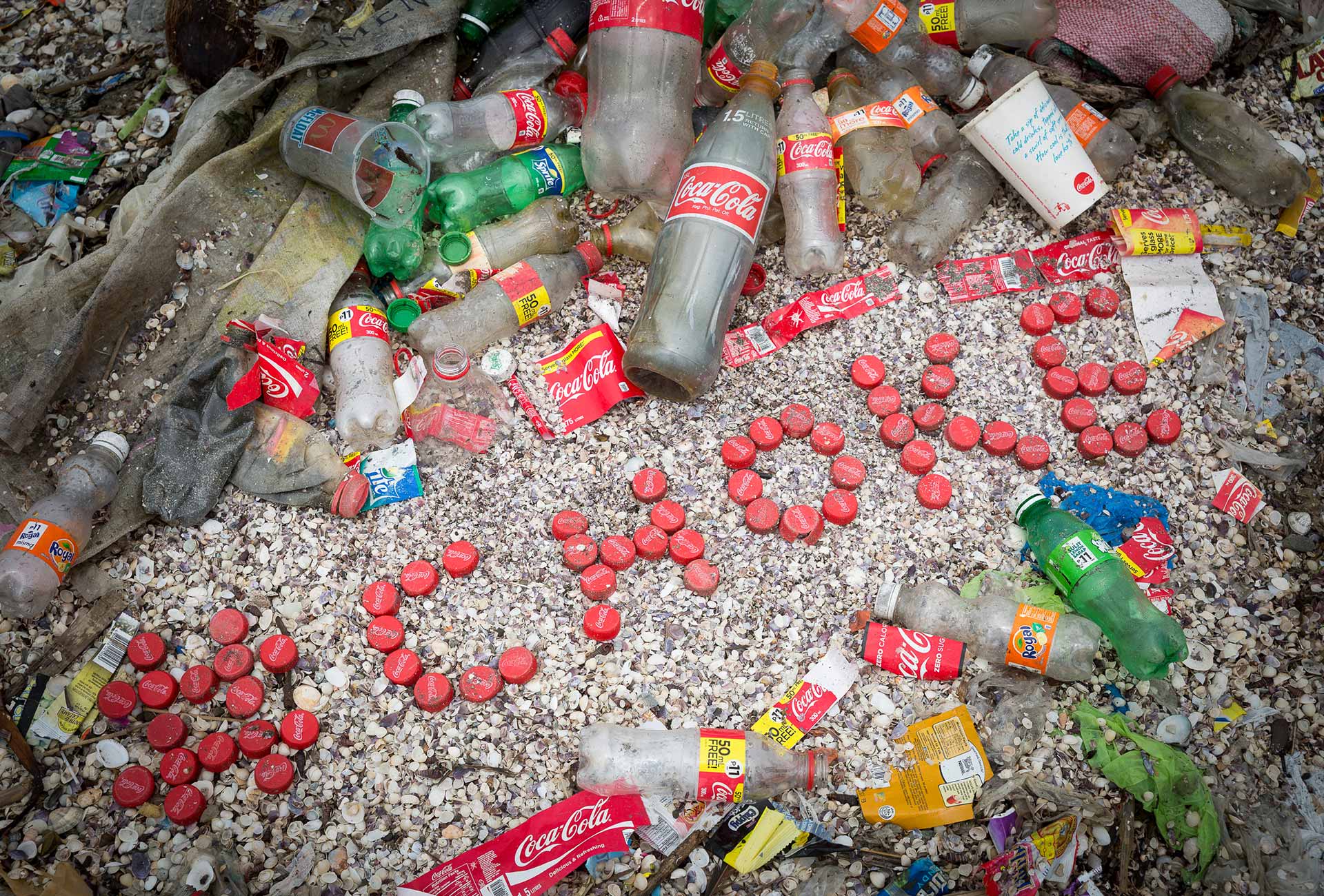 An arrangement of plastic waste including Coca Cola bottles that spells CHOKE