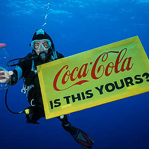 A Greenpeace diver holds a banner reading "Coca-Cola is this yours?" and a Coca-Cola bottle found adrift in the garbage patch. 

The crew of the Greenpeace ship MY Arctic Sunrise voyage into the Great Pacific Garbage Patch document plastics and other marine debris. The Great Pacific Garbage Patch is a soupy mix of plastics and microplastics, now twice the size of Texas, in the middle of the North Pacific Ocean.
