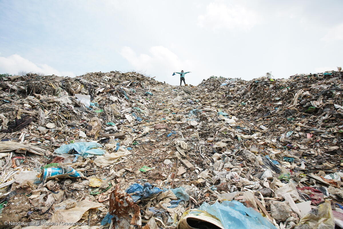A huge pile of rubbish, with a small human figure at top