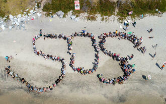 An aerial view of people on a beach spelling out SOS An aerial view of people on a beach spelling out SOS