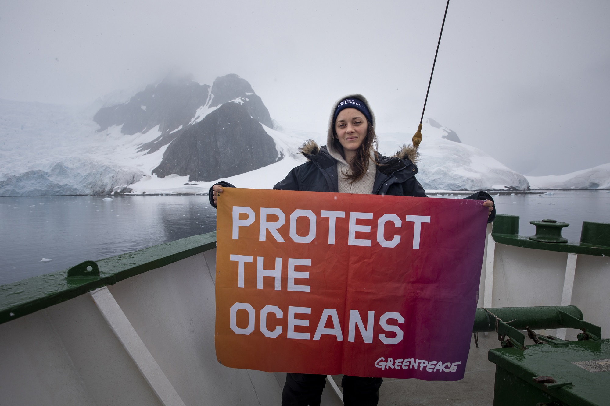 Actor Marion Cotillard holds a banner reading: 'Protect The Oceans' onboard the Arctic Sunrise