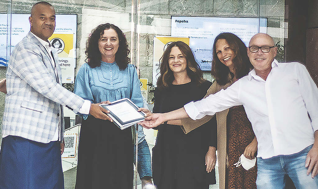 Five people holding the petition and smiling to camera