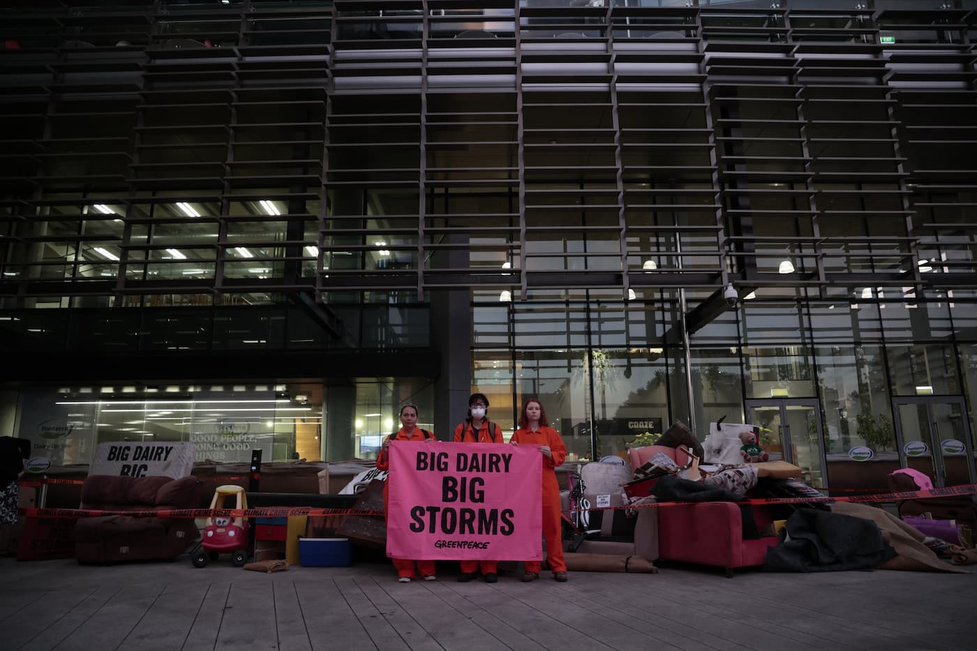 Activist hold a banner reading 'Big Dairy, Big Storms' at a protest outside Fonterra's HQ