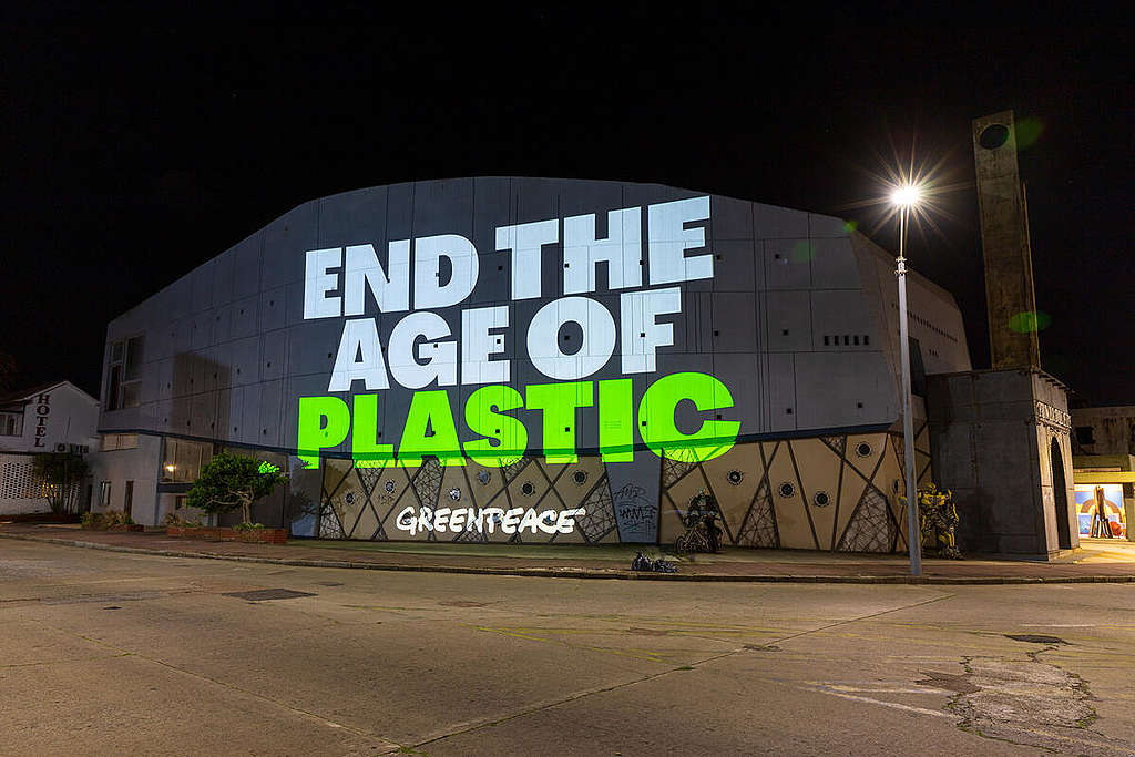 A Greenpeace projection on a factory in Uruguay saying "End the age of plastic"