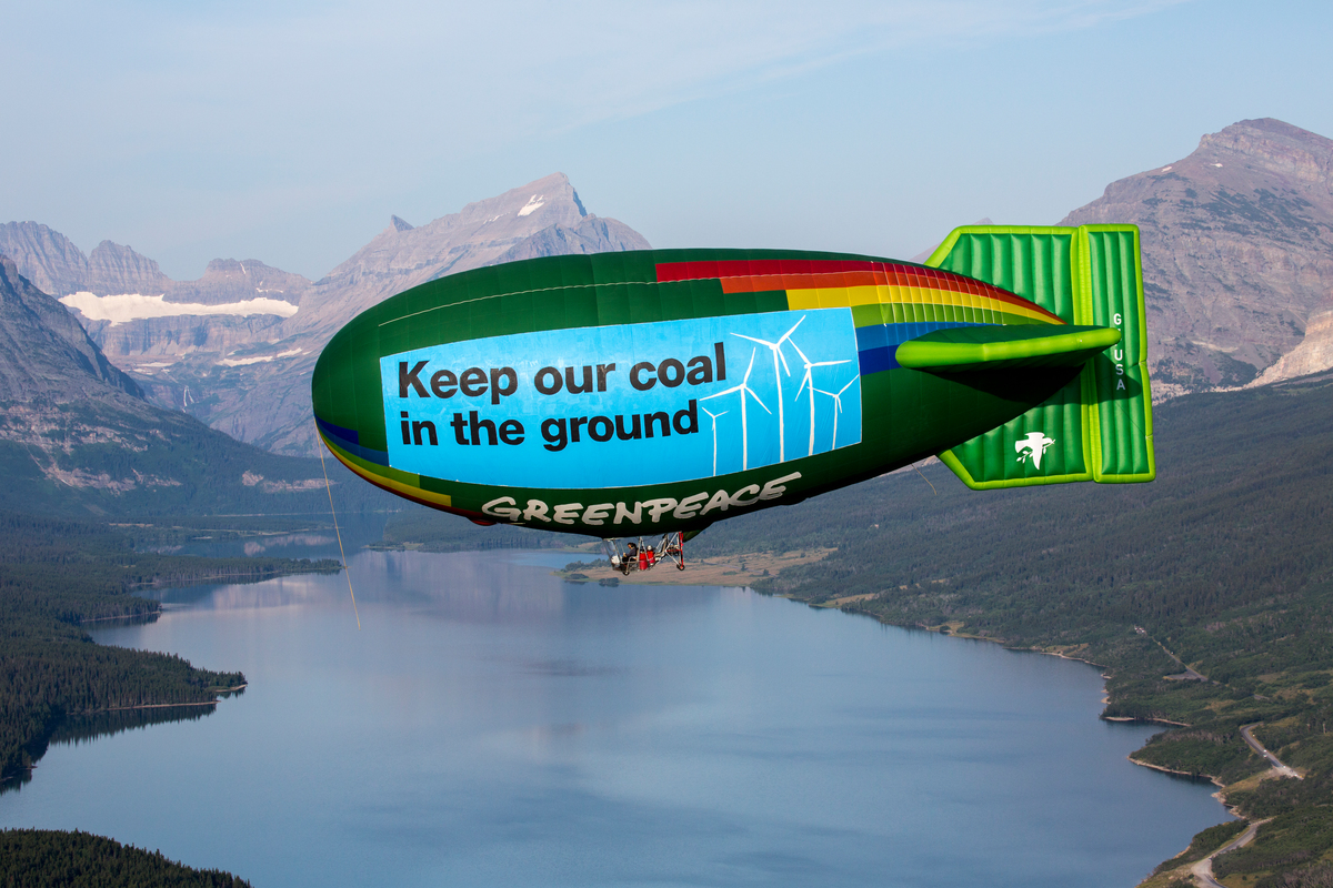 The Greenpeace thermal airship A.E. Bates flies by Glacier National Park near Babb with banners reading, "Coal exports fuel climate change" and "Keep our coal in the ground" to highlight the risks of coal export and mining. Coal mining companies are trying to boost exports of coal mined on public land in Montana and Wyoming to Asia, which would mean more carbon pollution and disruption to the environment and communities in the western United States.