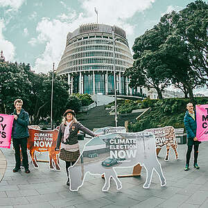 Activists stand alongside climate and agriculture campaigner Christine Rose with a 'disaster' cow installation at Parliament in Wellington, New Zealand