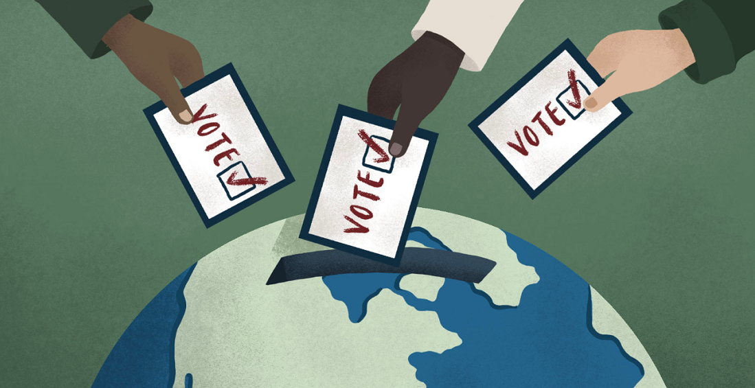 A graphic which shows three hands putting voting cards in a slot open on a globe.