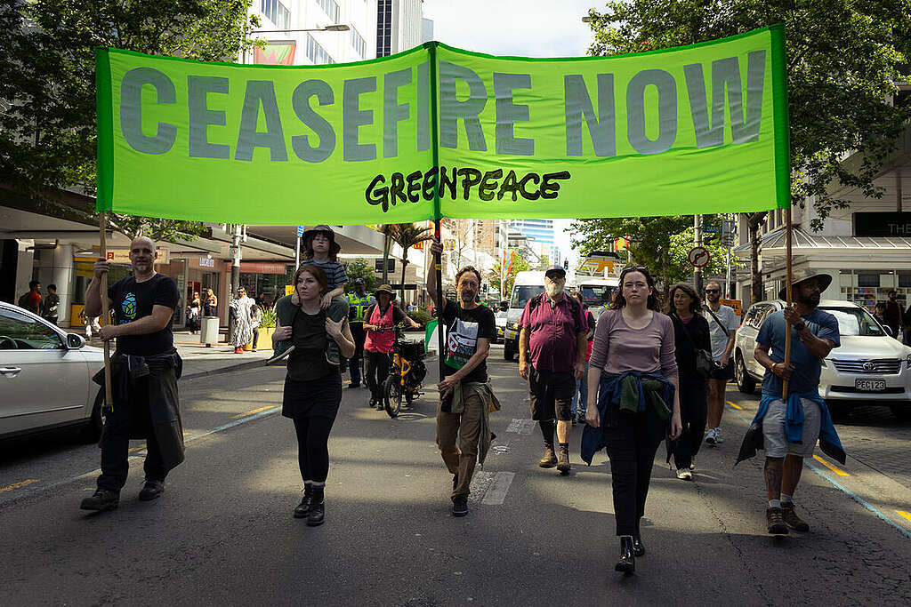 Greenpeace Aotearoa staff with a banner reading "Ceasefire Now" at a march in Auckland, New Zealand.