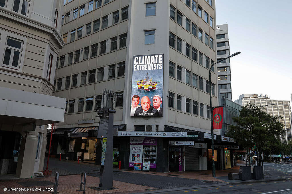 A billboard shows Christopher Luxon, David Seymour and Winston Peters with the words: Climate Extremists