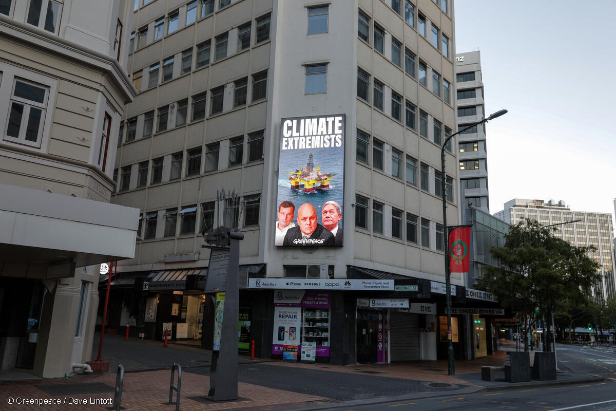 A billboard shows Christopher Luxon, David Seymour and Winston Peters with the words: Climate Extremists