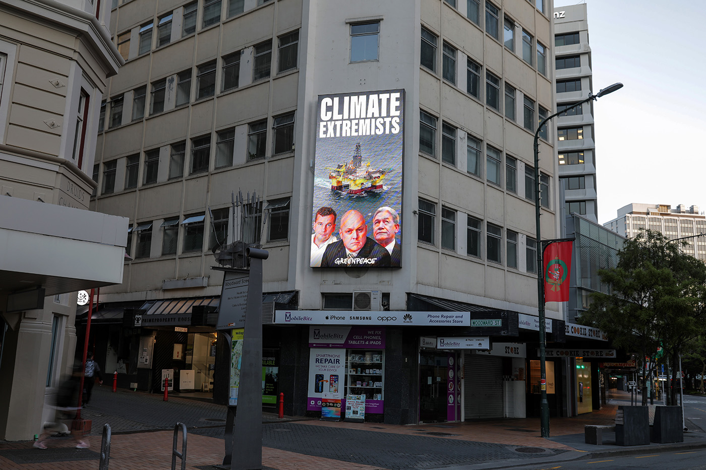 Christopher Luxon, David Seymour and Winston Peters are labelled as climate extremists on a billboard in Wellington with an offshore oil rig.
