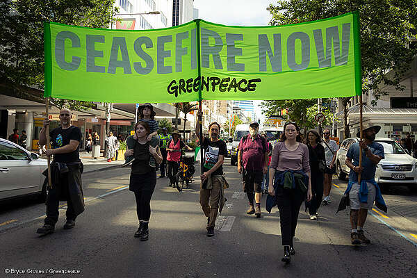 Greenpeace Aotearoa staff with a banner reading "Ceasefire Now" at a march in Auckland, New Zealand, for peace in the Israel/Palestine conflict.
