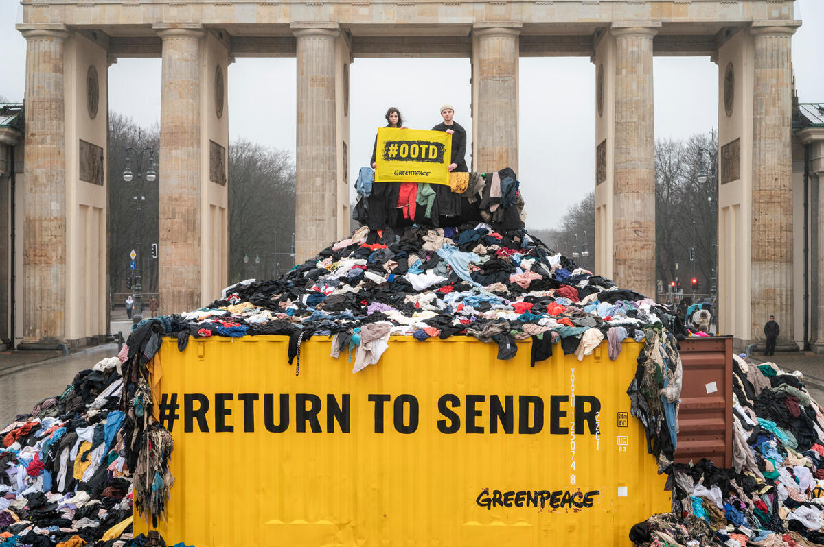 Greenpeace's activists are protesting fast fashion at the start of Berlin Fashion Week with a roughly 3.5 meter high and 12 meter wide mountain of textile waste. A slogan on the side of a container reads "return to sender"