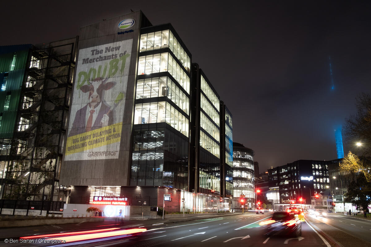 Greenpeace Aotearoa project a giant image on to the side of the Fonterra HQ in Auckland, New Zealand that reads “The New Merchants of Doubt - Big dairy delaying and derailing climate action.