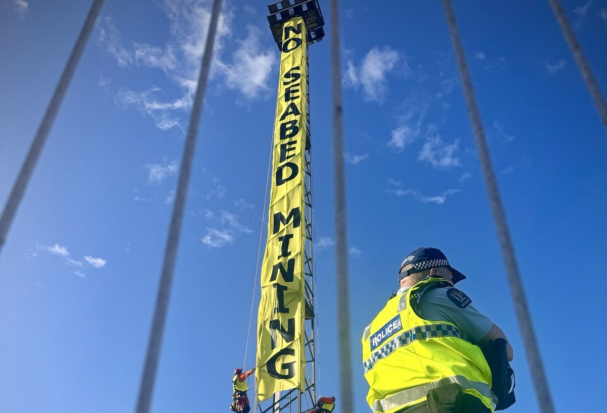 A 22m vertical banner on a light tower in Wellington reads No Seabed Mining © Dave Lintott / GREENPEACE
