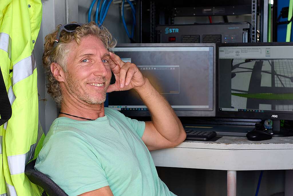 Grant Oakes, campaign operations advisor from Greenpeace International, looks at the camera from the container where the team works on the Seamount Expedition ship
