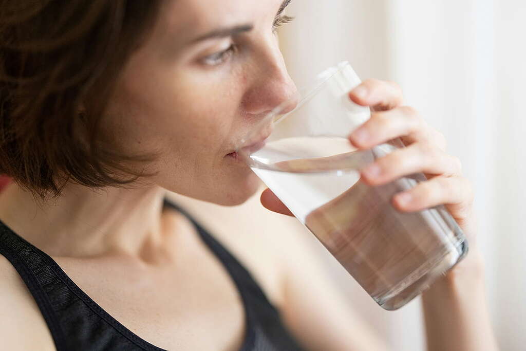 A woman drinks from a glass of water A woman drinks from a glass of water