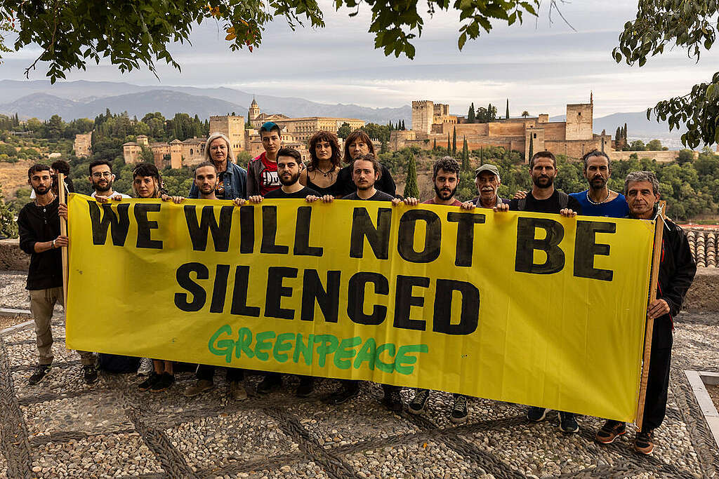 Greenpeace staff hold a banner that reads: We will not be silenced Greenpeace staff hold a banner that reads: We will not be silenced