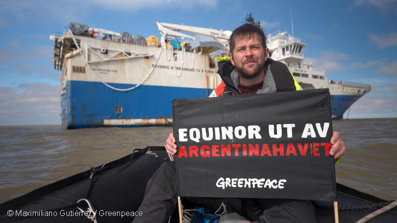 Activista de Greenpeace despliega una pancarta delante del barco sísmico para denunciar el impacto de las explosiones sísmicas y la actividad de exploración petrolera en la biodiversidad y los ecosistemas marinos.