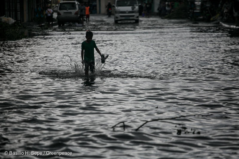 Un niño camina por una calle inundada debido al tifón Tisoy en la ciudad de Legazpi, en la provincia de Albay, Filipinas.