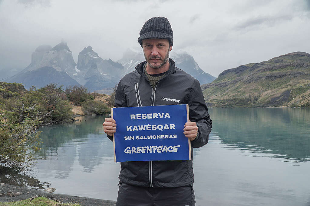 Benjamín Vicuña sosteniendo un cartel "Reserva Nawésqar sin salmoneras"