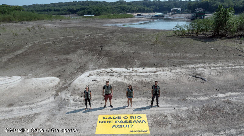 Activistas de Greenpeace con una pancarta con el mensaje "¿Dónde está el río que corría aquí?", en el lago Tarumã, en Manaos, donde la sequía es grave.