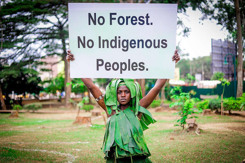Activiste qui montre une pancarte avec le slogan « No Forest. No Indigenous Peoples » (sic) (Pas de forêt. Pas de population