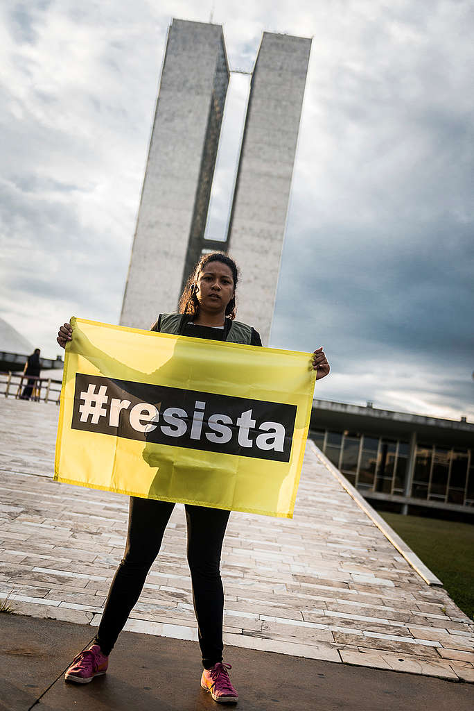 Ativista mostra banner com o nome do movimento Resista.