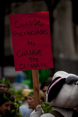 manifestante segura cartaz contra o aquecimento global.