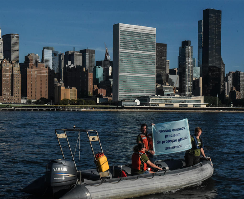 Ativistas seguram banner com a frase "Nossos oceanos precisam de proteção global".