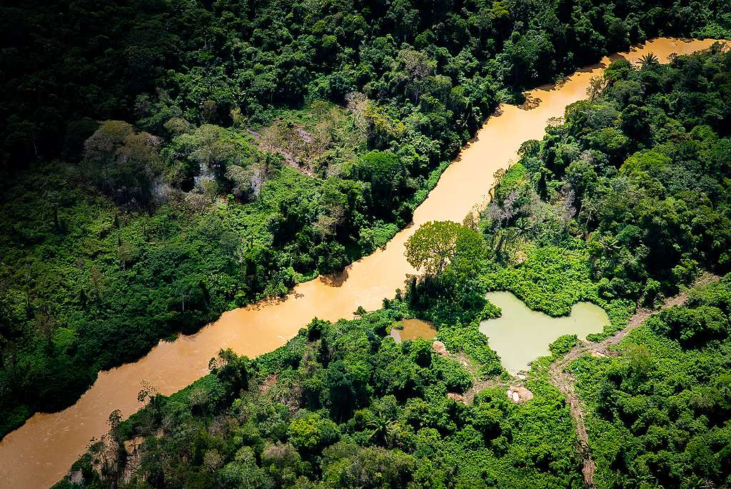 Foto aérea de rio na diagonal com estrada na parte esquerda