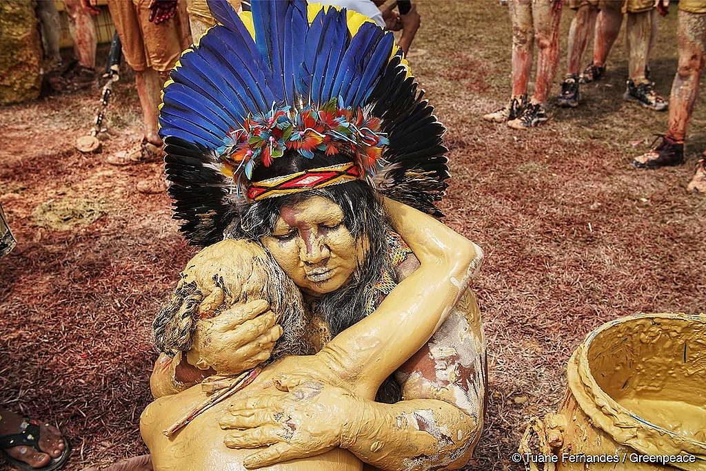 Foto de duas pessoas indígenas em um protesto.