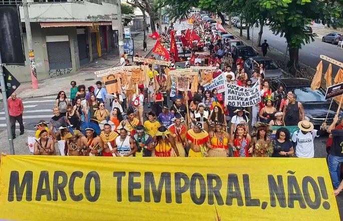 Foto de manifestação com pessoas voluntárias e lideranças indígenas, na rua contra o Marco Temporal