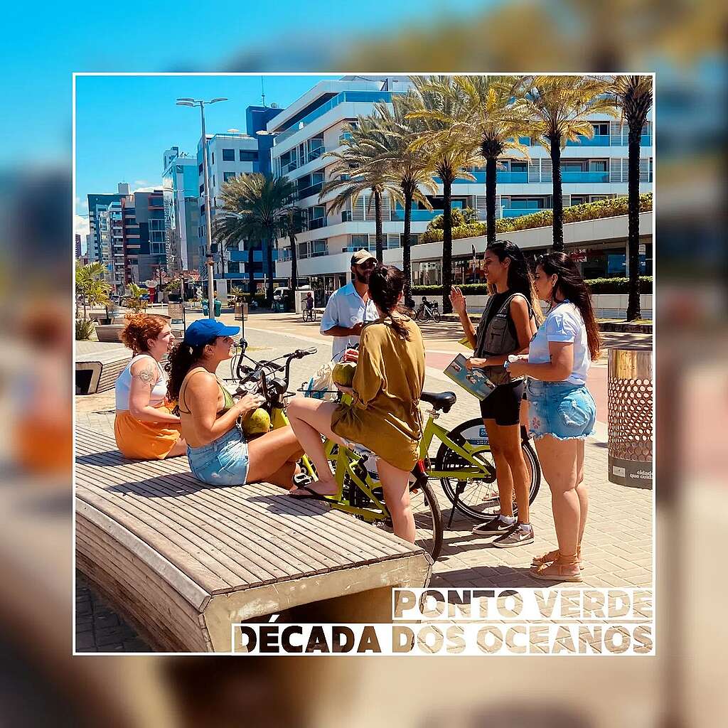 Fotografia de voluntários coletando assinaturas para petição na praia