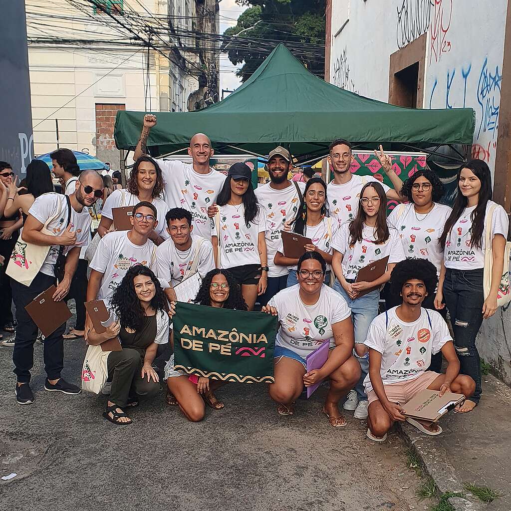 Pessoa voluntárias na rua em frente a tenda verde escura Pessoa voluntárias na rua em frente a tenda verde escura