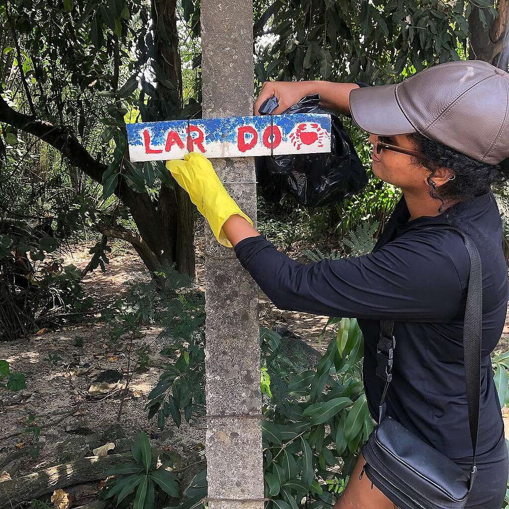 Fotografia de voluntária em ação de limpeza