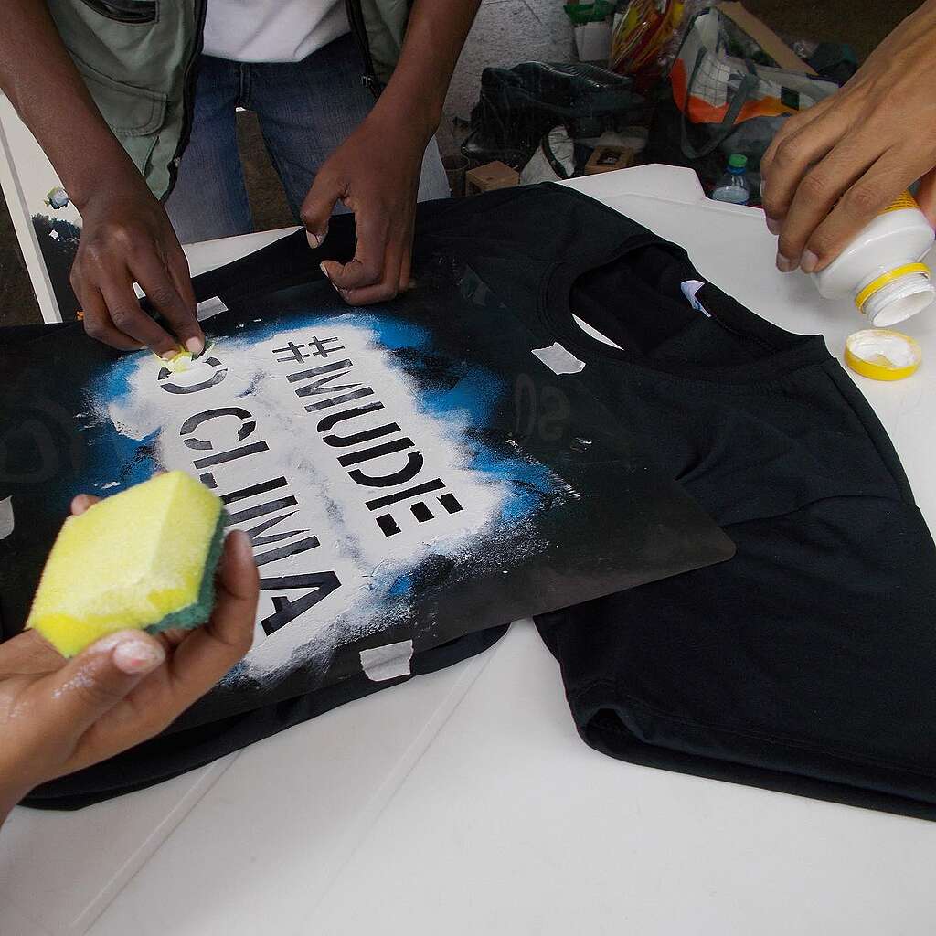 Fotografia de voluntários fazendo arte em camiseta