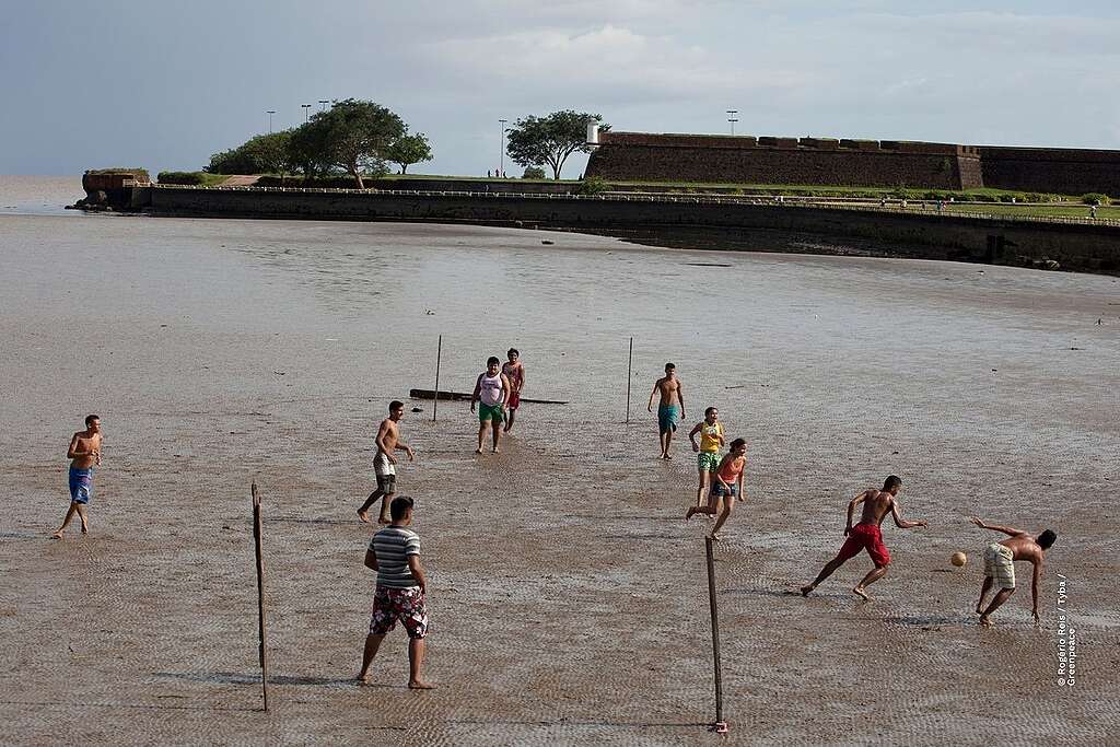 foto de drone de aproximadamente dez jovens jogando futebol no Rio Amazonas, no Amapá.

